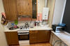 На кухне: газовая плита, нагреватель воды, посуда, микроволновка, жалюзи на окнах